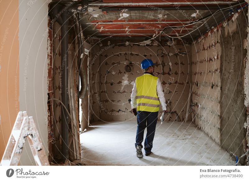 Vorarbeiter oder unkenntlicher Architekt bei der Arbeit an Bauplänen auf der Baustelle. Heimwerken Haus Polier Blaupausen professionell Isolierung Ohrenschützer