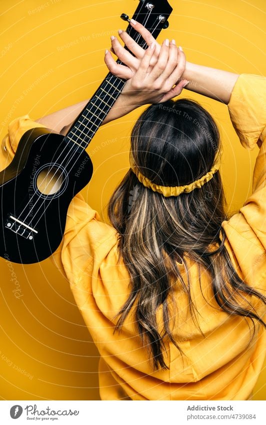 Frau wirft Ukulele im hellen Studio Spieler Pause werfen Musik Instrument Stil Hobby cool Tierhaut redaktionell Model Musiker Arme hochgezogen akustisch