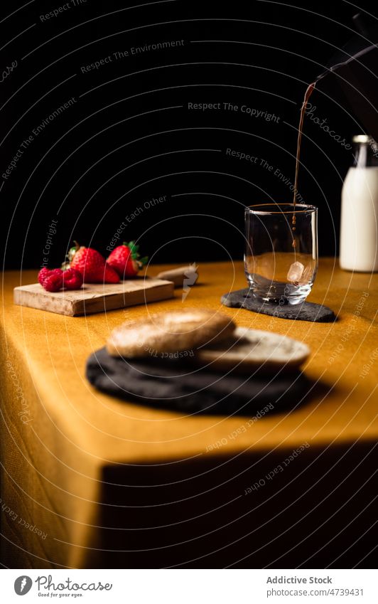 Frischer Kaffee im Glas zum Frühstück mit Beerenbagel eingießen Erdbeeren Moka-Topf Bagel Himbeeren dienen Morgen vorbereiten Prozess lecker melken appetitlich