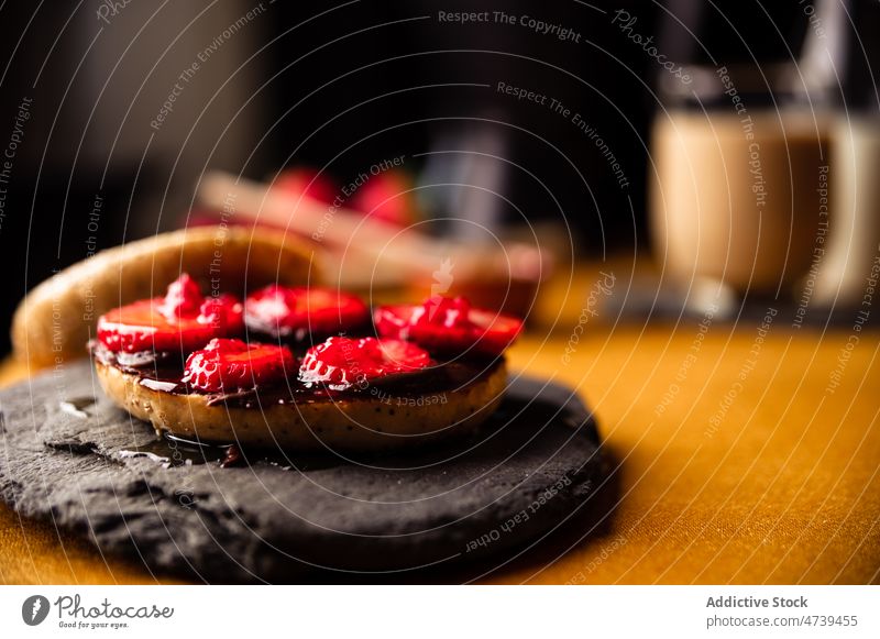 Leckerer süßer Bagel mit Erdbeere auf Steintablett Erdbeeren Himbeeren Scheibe Dessert Schokolade Schiefer Teller selbstgemacht Beeren lecker geschmackvoll