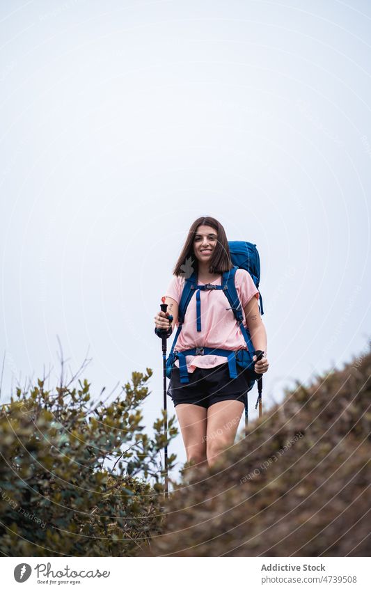 Fröhliche Frau mit Trekkingstöcken in der Natur Wanderer Mast Abenteuer Reise Rucksack Aktivität Wanderung erkunden Sommer positiv Backpacker kleben Tourist