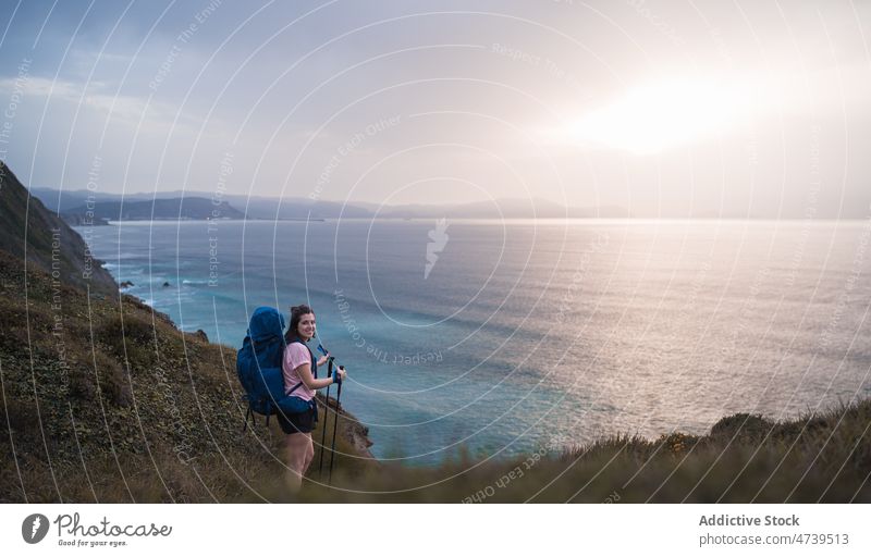 Fröhlicher Wanderer am Ufer bei Sonnenuntergang Frau Trekking Abenteuer Natur MEER Meeresufer Hafengebiet Mast Abend kleben Wasserseite Glück Seeküste