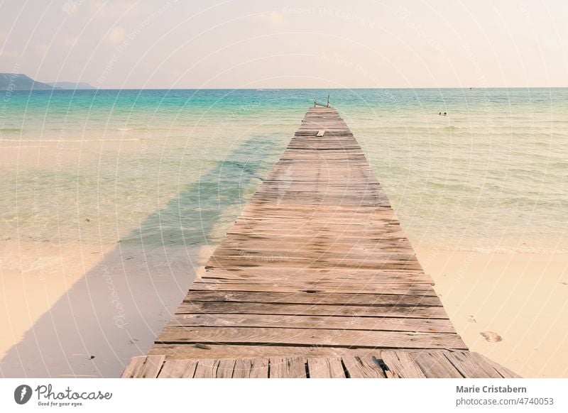 Blick auf eine Holzpromenade, die zum weißen Sandstrand der Insel Koh Rong Samloen führt, einem beliebten Sommerurlaubsziel in Kambodscha Sommerzeit