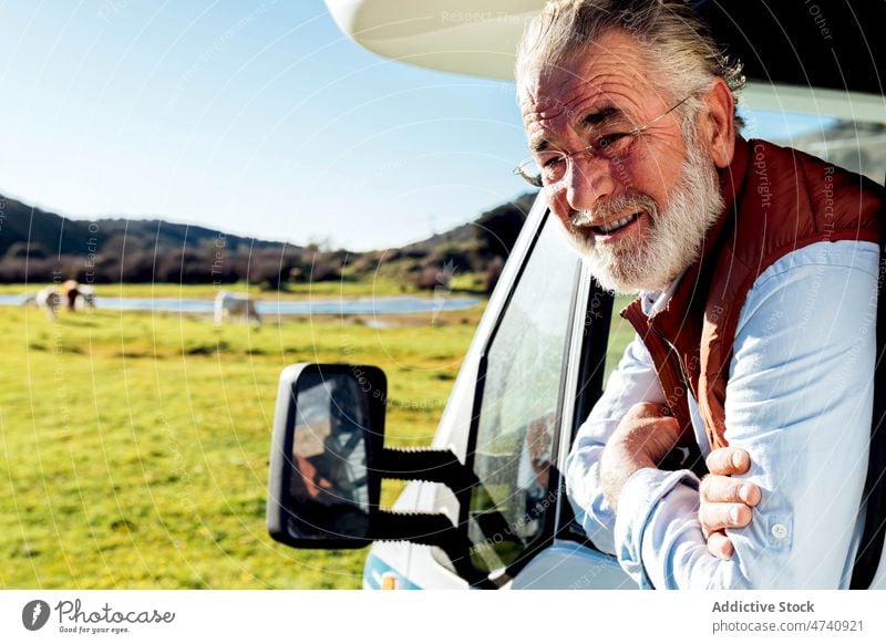 Mann schaut aus dem Fenster eines Wohnwagens in der Natur Wohnmobil PKW rv Feld Porträt Autoreise Reise beobachten Anhänger Landschaft Verkehr geparkt männlich