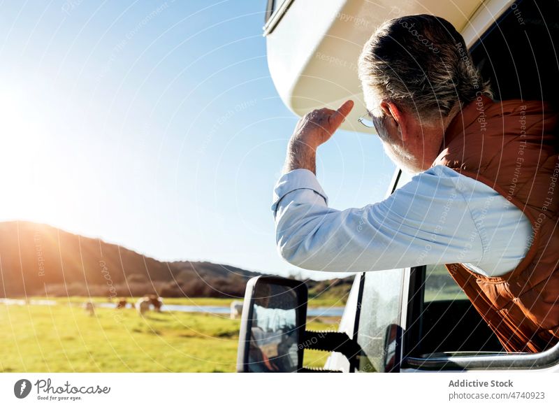 Gesichtsloser Mann schaut aus dem Fenster eines Wohnwagens in der Natur Wohnmobil PKW rv Feld Autoreise Reise beobachten Anhänger Landschaft Verkehr geparkt