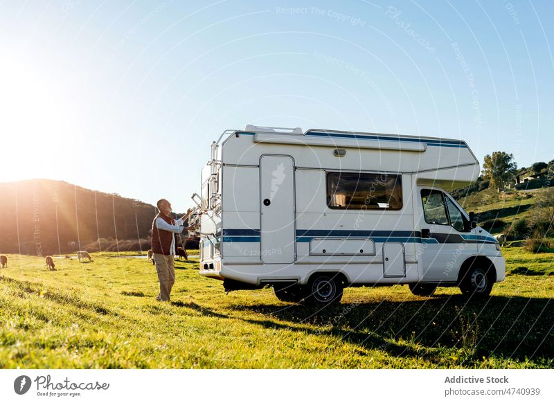 Man u sing pull out ladder on camper Mann Wohnmobil rv Natur Autoreise Reise Wohnwagen Landschaft Schritt Laufmasche Falten Anhänger Verkehr Feld geparkt