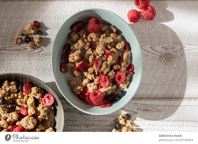 Schale mit Müsli und Beeren auf dem Tisch zum Frühstück Schalen & Schüsseln Supernahrung Joghurt Morgen dienen Himbeeren Blaubeeren Gesundheit Molkerei Portion