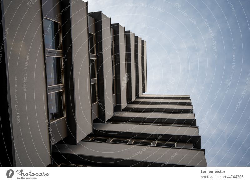 Fassdade eines mehrstöckigen Wohnhauses mit Blick nach oben Fassade Balkon Beton Plattenbau Modern Grau blick nach oben Fenster Architektur Himmel sicht Bau