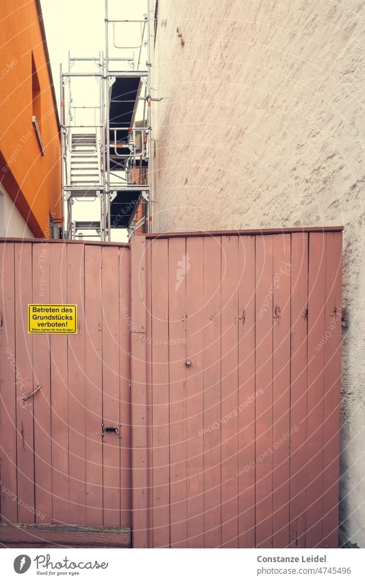 Holztor zwischen zwei Häusern mit Betreten verboten Schild. Hauswand Tor Eingang geschlossen Eingangstor Holztür Baugerüst Eingangstür Tür alt Sicherheit