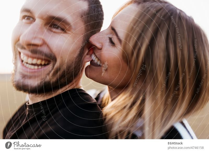 Close up Frauen beißen Mann Ohr auf dem Lande umarmt. Freund und Freundin in der Liebe beißend Biss abschließen umarmend Zwei Personen Paar Landschaft Umarmen