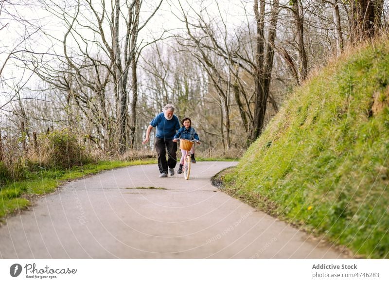 Großvater unterrichtet Mädchen beim Fahrradfahren auf dem Lande Hobby Freizeit Kindheit Zeit verbringen Mitfahrgelegenheit Landschaft Hilfsbereitschaft