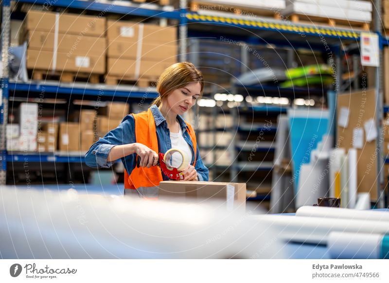 Junge Frau bei der Arbeit an einem Industriearbeitsplatz Business Ladung selbstbewusst liefernd Versand Verteilung Mitarbeiter Fabrik Ware industriell Job