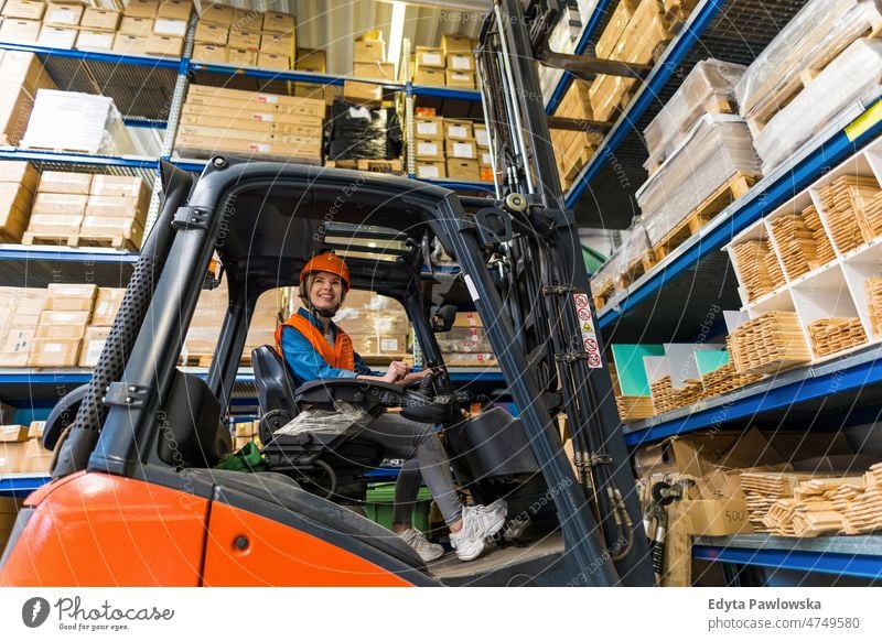 Junge Gabelstaplerfahrerin bei der Arbeit in einem Lagerhaus Business Ladung selbstbewusst liefernd Versand Verteilung Mitarbeiter Fabrik Frau Ware industriell