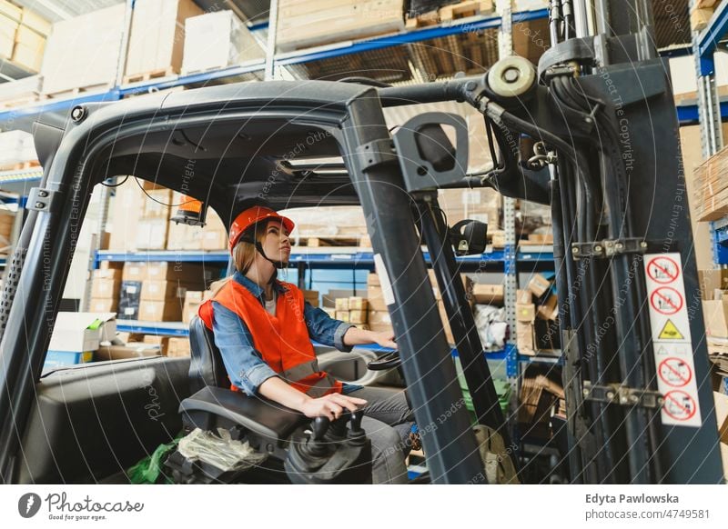 Junge Gabelstaplerfahrerin bei der Arbeit in einem Lagerhaus Business Ladung selbstbewusst liefernd Versand Verteilung Mitarbeiter Fabrik Frau Ware industriell