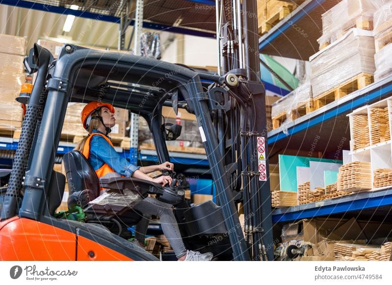 Junge Gabelstaplerfahrerin bei der Arbeit in einem Lagerhaus Business Ladung selbstbewusst liefernd Versand Verteilung Mitarbeiter Fabrik Frau Ware industriell