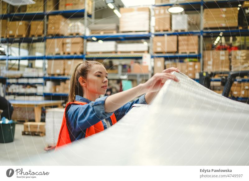 Junge Frau bei der Arbeit an einem Industriearbeitsplatz Business Ladung selbstbewusst liefernd Versand Verteilung Mitarbeiter Fabrik Ware industriell Job