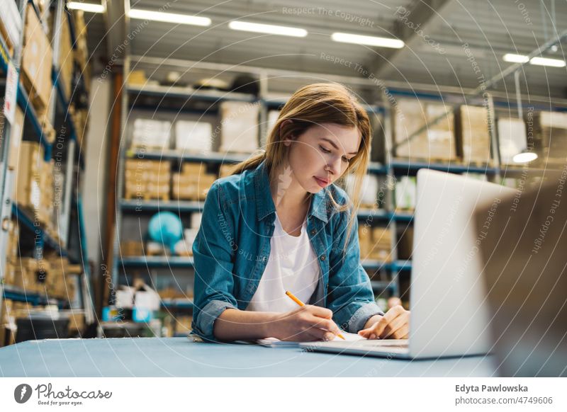 Frau benutzt Laptop im Lagerhaus Business Ladung selbstbewusst liefernd Versand Verteilung Mitarbeiter Fabrik Ware industriell Industrie Job