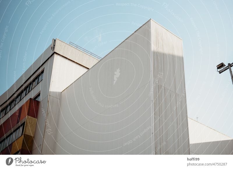 Weisse Wellblechfassaden einer Lagerhalle im Hafen vor blauem Himmel Architektur Industriefassade Blauer Himmel Schuppen minimalistisch Hafengebäude