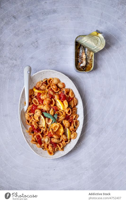 Teller mit köstlicher italienischer Pasta Spätzle Tomate Saucen Sardinen Zitrone Tisch Mittagessen Conchiglie Speise italienische Küche Dose lecker Lebensmittel