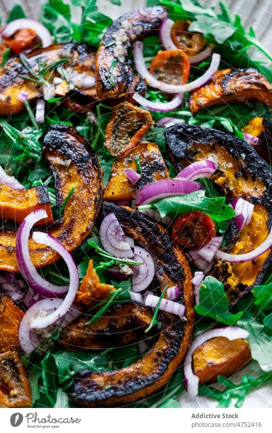 Veganer Salat mit gegrilltem Kürbis Salatbeilage gesunde Ernährung Gemüse Speise Zwiebel Rucola Mittagessen Hintergrund Portion Feinschmecker Braten frisch