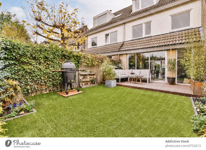 Terrasse mit Couch und Tisch beim Haus Hinterhof Sofa Garten Hof Liege wohnbedingt gemütlich Gebäude Anwesen verweilen grün Vorstadt Komfort Design Zeitgenosse