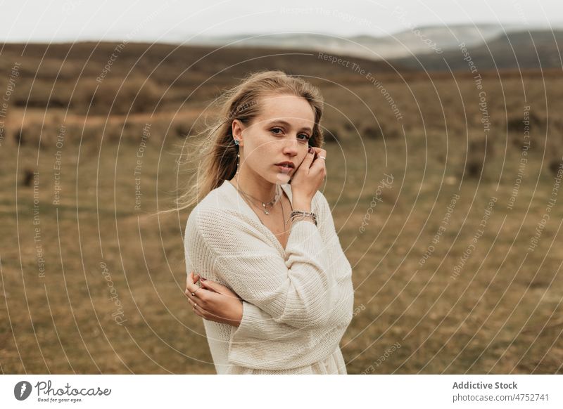 Frau steht auf einem grasbewachsenen Feld auf dem Lande Landschaft Porträt Natur Vorschein feminin Stil attraktiv jung ländlich blond Umwelt trist rustikal