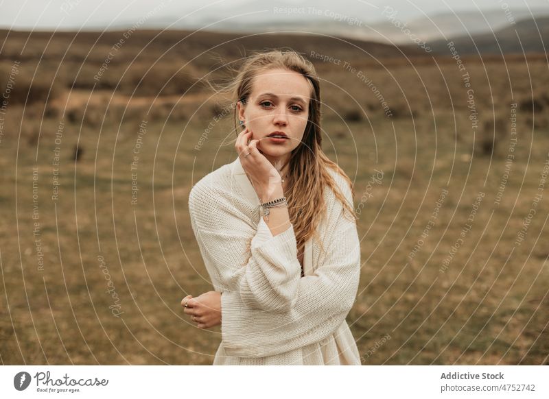 Frau steht auf einem grasbewachsenen Feld auf dem Lande Landschaft Porträt Natur Vorschein feminin Stil attraktiv jung ländlich blond Umwelt trist rustikal