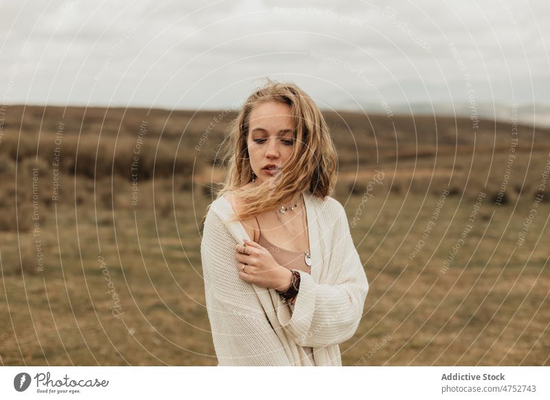 Frau steht auf einem grasbewachsenen Feld auf dem Lande Landschaft Porträt Natur Vorschein feminin Stil attraktiv jung ländlich blond Umwelt trist rustikal