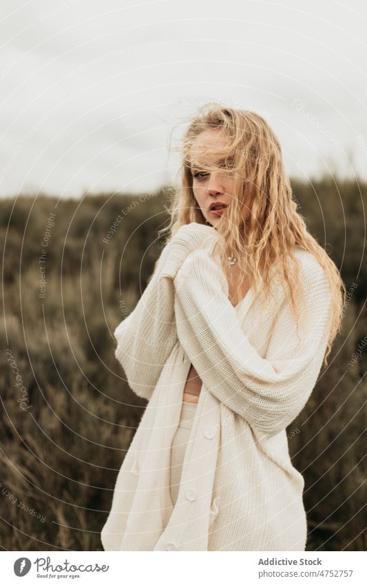 Frau steht auf einem grasbewachsenen Feld auf dem Lande Landschaft Porträt Natur Vorschein feminin Stil attraktiv jung ländlich blond Umwelt trist rustikal