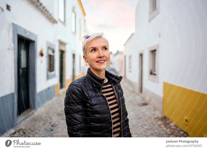 Porträt einer blonden modernen Frau in städtischer Umgebung Großstadt urban Lebensmitte Faro historisch entspannend Stehen Stadtzentrum Gebäude Fröhlichkeit