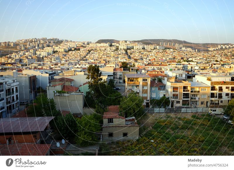 Berghang mit modernen Wohnhäusern und Hochhäusern im Licht der untergehenden Sonne im Sommer im Stadtteil Cigli in Izmir am Ägäischen Meer in der Türkei