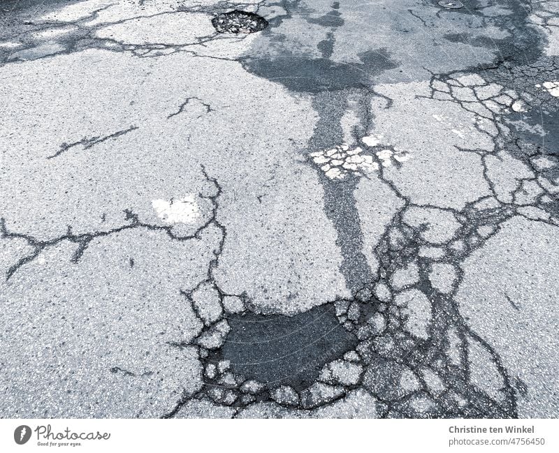 Risse und Schlaglöcher im Asphalt Straße Straßenbelag Asphaltierung Asphaltdecke alte Straße kaputt aufgeplatzt Muster Strukturen & Formen Verkehrswege Linien