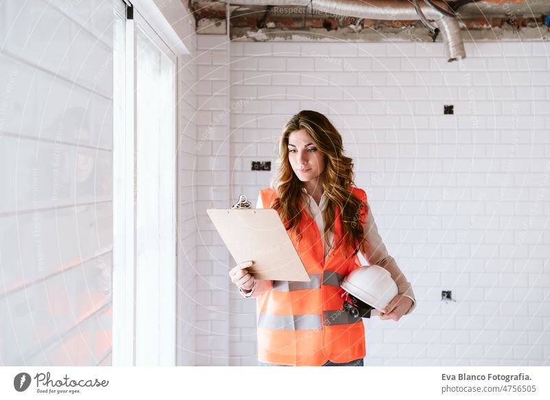 Inspektorin oder Architektin, die eine Küche auf der Baustelle überprüft. Heimwerken Frau Überprüfung heimwärts Laptop unkenntlich Handy Blaupausen