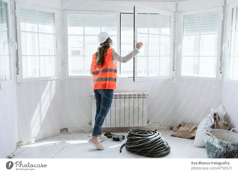 Inspektorin oder Architektin, die auf der Baustelle die Fenster kontrolliert. Heimwerken Frau Überprüfung heimwärts Laptop unkenntlich Handy Blaupausen