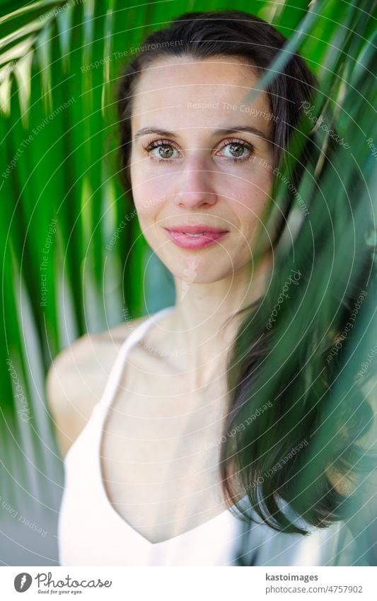 Junge schöne natürliche fröhliche Frau mit gesundem Gesicht und Haut in exotischen Grün. Closeup frisches Gesicht eines attraktiven Mädchens. Sommer-Modell. Natürliche Schönheit Konzept.