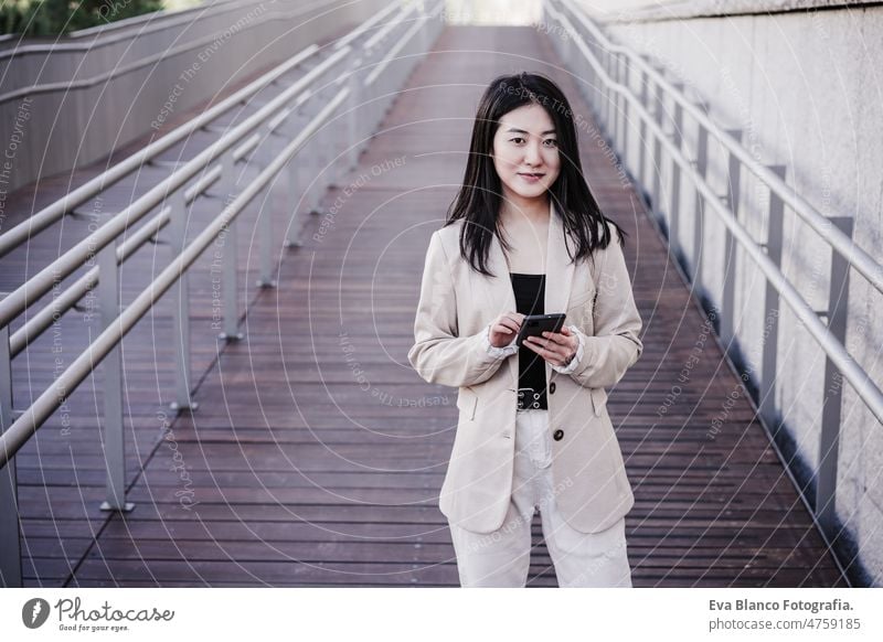 zuversichtlich, schöne chinesische Geschäftsfrau mit Handy in der Stadt. Technik Chinesisch asiatisch Frau Laptop Technik & Technologie Café Kaffee Kantine