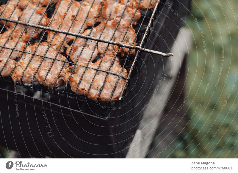 Grillen von Hühnerfleisch im Garten Grillrost Frühling Grillsaison Hähnchen Lebensmittel Gartenparty Grillparty Essen zubereiten Fleisch grillen gegrillt Sommer