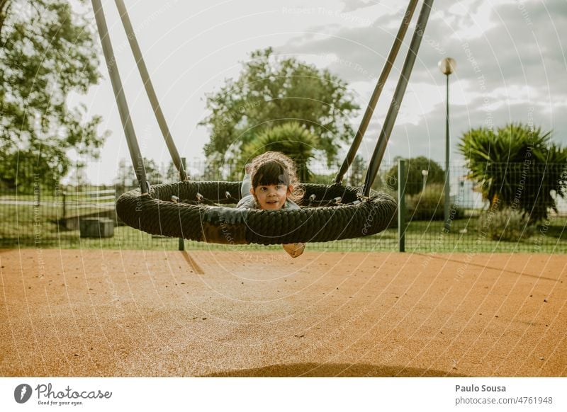 Nettes Mädchen spielt auf dem Spielplatz niedlich 3-8 Jahre Kaukasier Spielplatzgeräte pendeln Park Tag Glück Farbfoto Außenaufnahme Freude Mensch Kind Kindheit