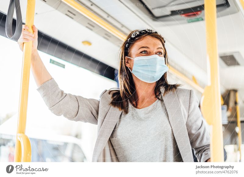 Eine junge Frau mit Maske, die mit dem öffentlichen Bus pendelt Reisender Pandemie Mundschutz Erwachsener Ausflug Auto Fahrzeug lässig Lächeln Laufwerk Sitzen