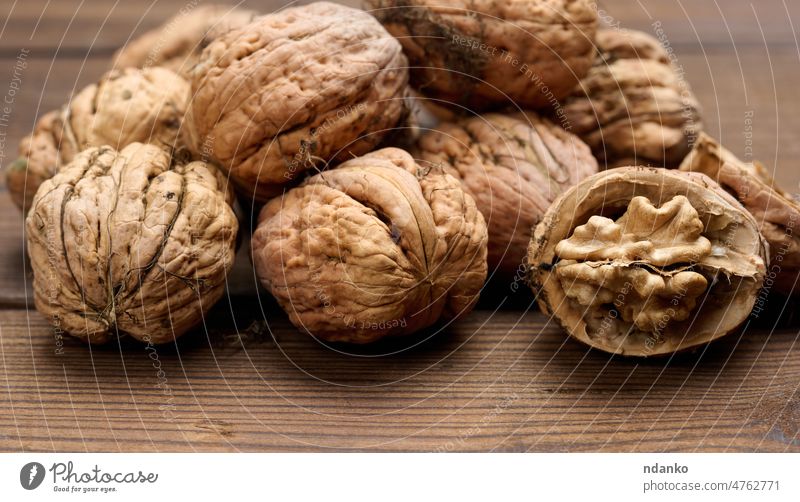 Walnuss auf braunem Holztisch, Nahaufnahme Kernel Herbst gebrochen zugeklappt geknackt lecker Diät trocknen Lebensmittel frisch Frucht Menschengruppe hart Ernte