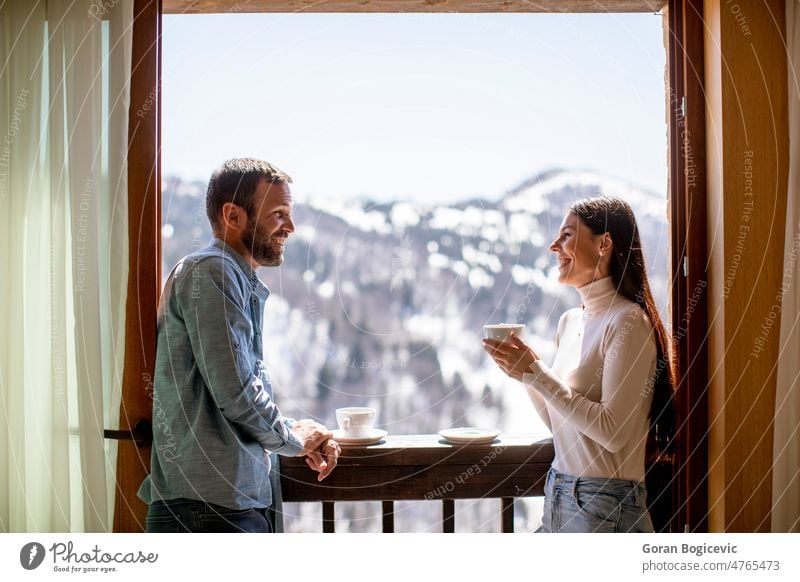 Junges Paar mit einer Tasse heißem Tee am Winterfenster Appartement attraktiv schön Getränk Windstille Kaffee niedlich trinken genießend Gesicht Frau heimwärts