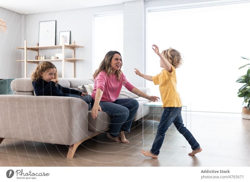 Mutter umarmt Sohn in der Nähe der Tochter Kinder Geschwisterkind Zeitvertreib Zeit verbringen Wohnzimmer Umarmung Liebe Kindheit kuscheln Streicheln Umarmen