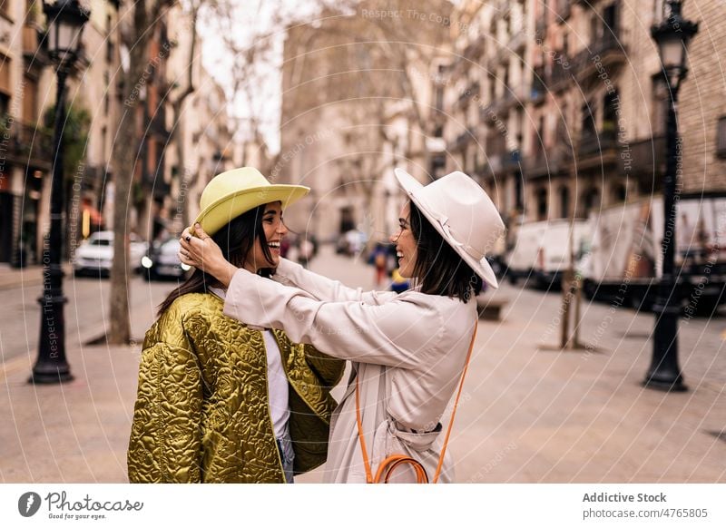 Fröhliche Frauen mit Hüten in der Stadt Freund Straße Großstadt Stil trendy Mode urban feminin Hut Zeitvertreib Freundschaft bester Freund Zusammensein Freundin