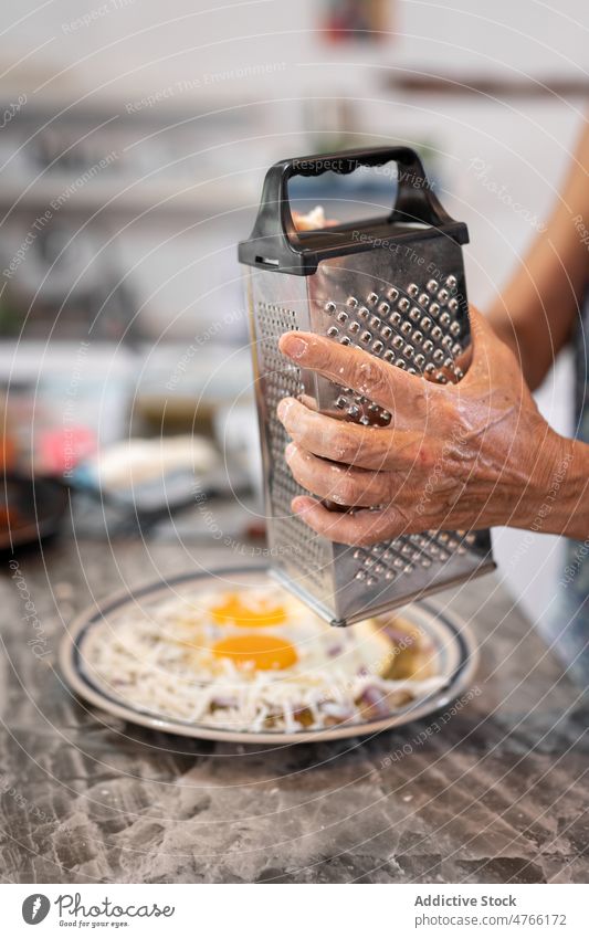 Unbekannte Person reibt Käse auf Essen mit Eiern und Nachos Koch Speise kulinarisch Mahlzeit nachos Tortilla Küche gebraten Gitter mexikanisches Essen dienen