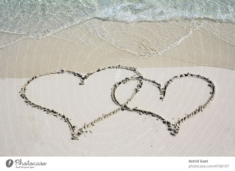 Zwei Herzen im Sandstrand vor dem Meer liebe urlaub sand meer sandstrand wasser welle ferien erholung freizeit baden schwimmen badeurlaub strandurlaub erholen