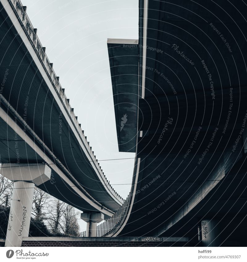 düstere Ansicht zweier sich kreuzenden Hochstrassen Hochstraße Straße Beton Moderne Architektur Betonsäulen Straßenbeleuchtung Diagonale Wolkenloser Himmel