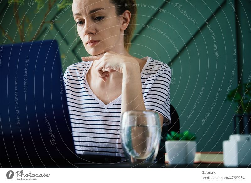 Frau arbeitet im Home Office mit Laptop heimwärts Büro Arbeit abgelegen Arbeitsplatz Freiberufler Business beschäftigt Überarbeitung Tisch Wasser Glas Pflanze