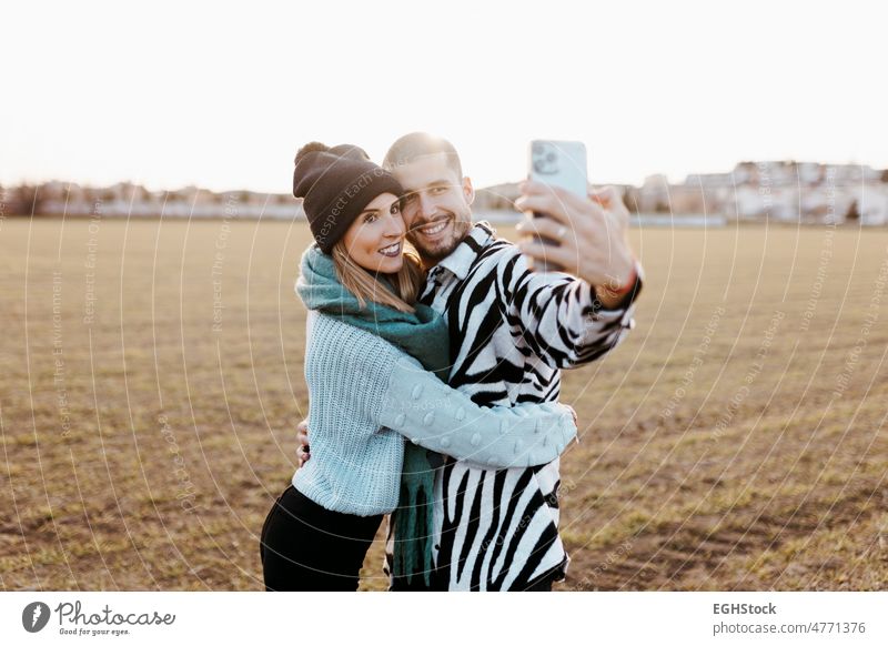 Paar nimmt ein Selfie Foto mit Handy in der Landschaft bei Sonnenuntergang Mobile Telefon Glück Zusammensein Zusammengehörigkeitsgefühl Wiese Romantik