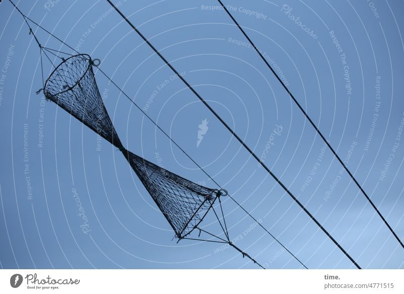 trocknende Fischreuse am Seil vor dunklem Himmel in Schräglage fischreuse seil himmel hängen parallel netz gewebt struktur fischfang maritim kegelförmig wolken