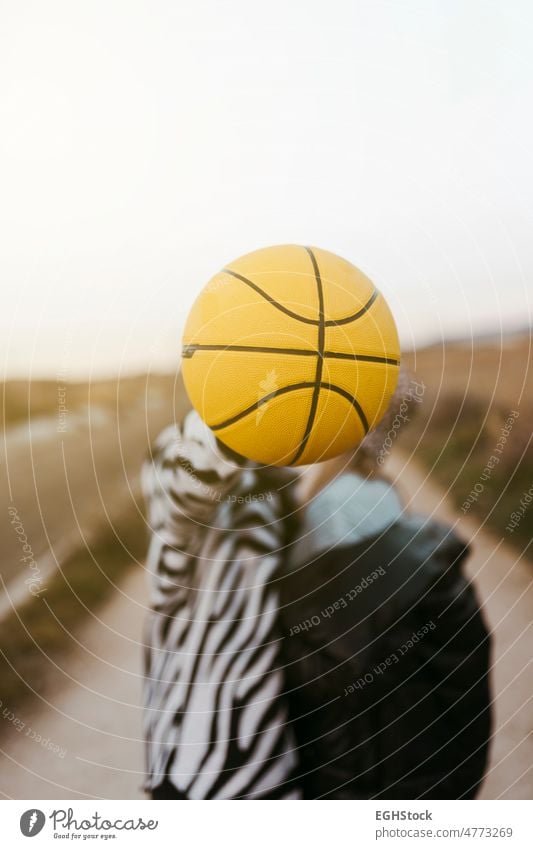 junges Paar küsst sich heimlich hinter einem gelben Basketball Liebe Kuss hinten Küssen Ball abschließen Zwei Personen Landschaft verstecken umarmt Umarmen